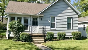 A single-story house with a front porch, a small front yard, and a clear sky.
