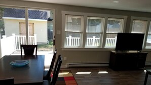 A dining area with a table, chairs, and a TV.