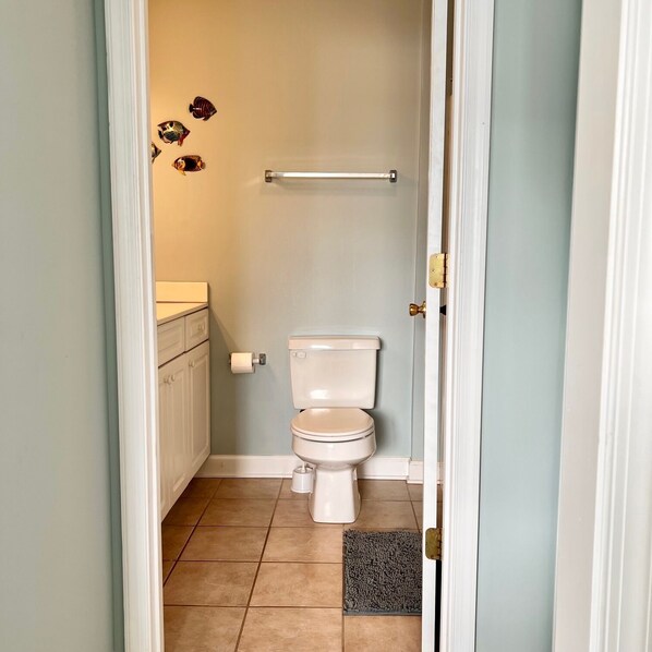 A small bathroom with a toilet, a towel rack, and a toilet paper holder.