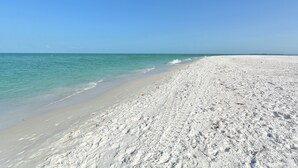 A wide, sandy beach with clear turquoise water and a clear blue sky. -  Beautiful, Gulf-Front Home on Bean Point--Halcyon House (Anna Maria)