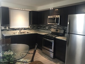 Enjoy cooking in this well-equipped kitchen with a sink, stove, oven, and refrigerator.