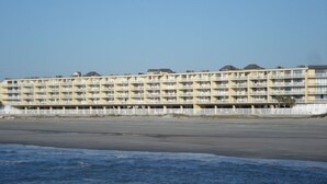Ein mehrstöckiges Hotel mit Balkonen in Strandnähe.