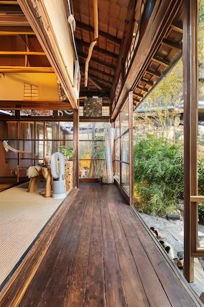 Une terrasse en bois donnant sur un jardin.