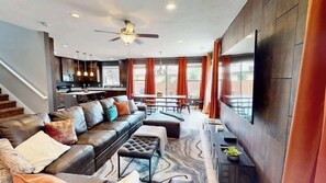 A modern living room with a sofa, ottoman, and a dining area with a table and chairs. - Entrada at Moab - 430, Brand New 4 Bedroom Luxury T (Moab)