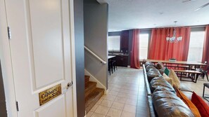 A hotel room with a staircase leading to a dining area, a sofa, and a sign on the door. - Entrada at Moab - 430, Brand New 4 Bedroom Luxury T (Moab)