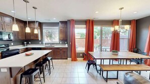 A modern kitchen with a central island, bar stools, and a dining area with a bench. - Entrada at Moab - 430, Brand New 4 Bedroom Luxury T (Moab)
