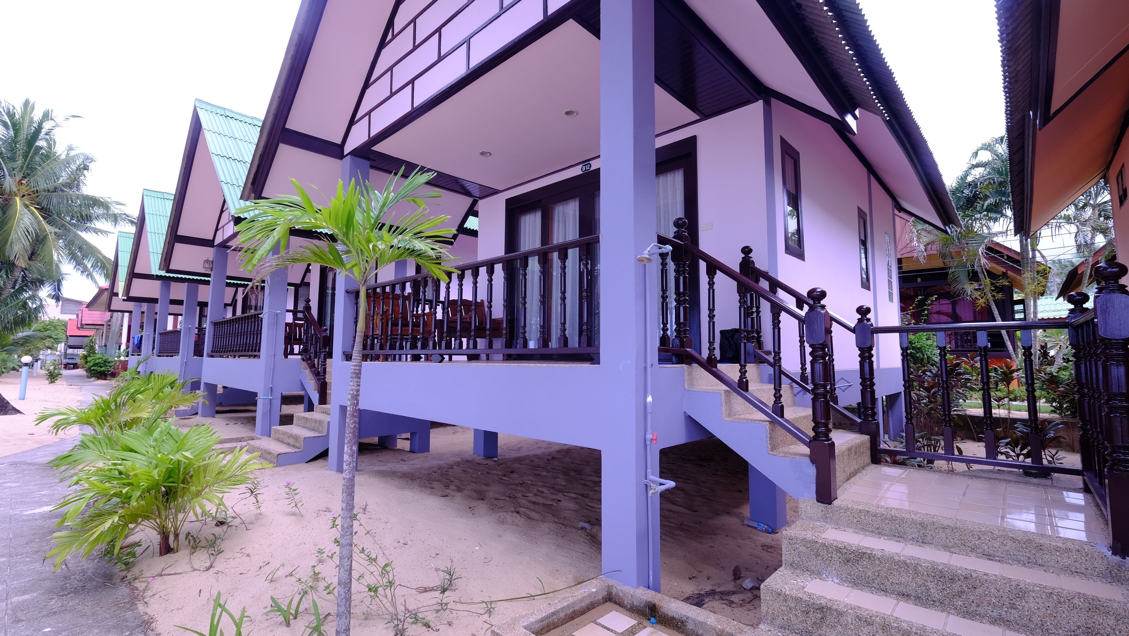 A two-story building with a balcony and a staircase.