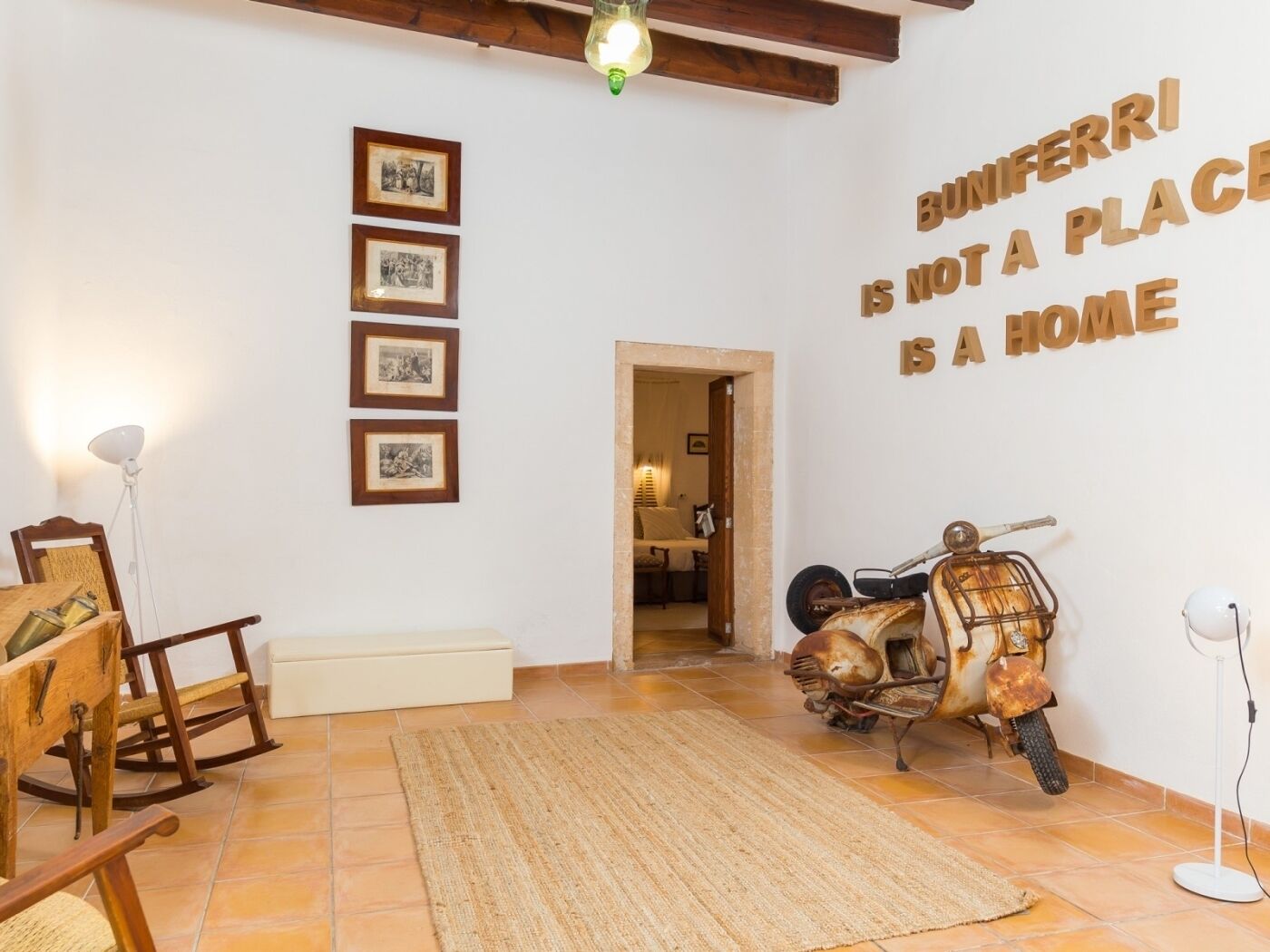 Ein Zimmer mit rustikalem Dekor, inklusive eines Vintage-Motorrads, Holzschaukelstühlen und gerahmten Bildern an der Wand.