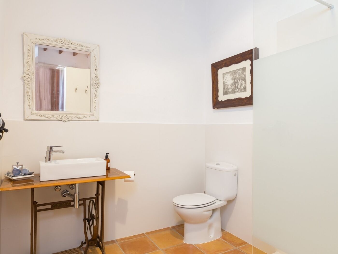 A bathroom with a white sink, mirror, and toilet.