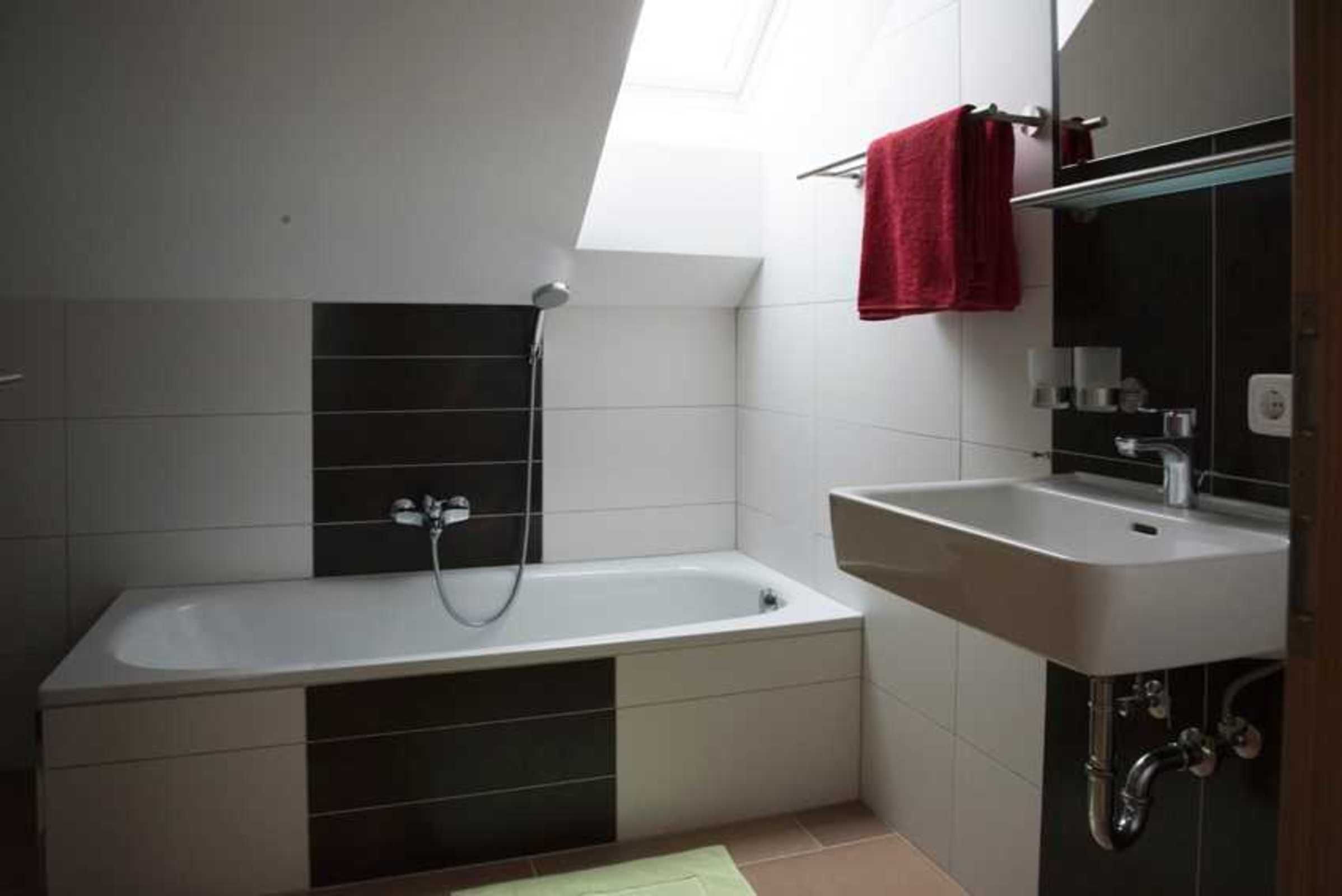 A modern bathroom with a bathtub, a sink, and a shower.