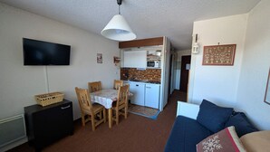 A compact living space with a dining area, kitchenette, and a sofa. - Studio ski-in/ski-out 22m², pets allowed, with parking (Montgenèvre)