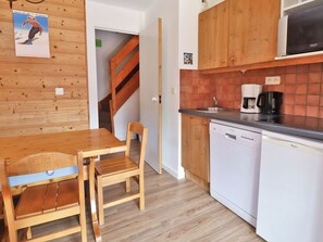 A kitchen with wooden cabinets, a dishwasher, and a coffee maker. - Charming 2* Ski-In Duplex, 6 Pers, South Balcony (Méribel)