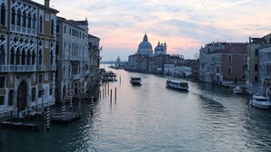 Un canal flanqueado por edificios históricos, con una cúpula destacada al fondo.