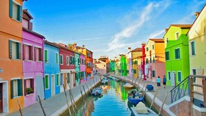 Un canal estrecho bordeado por edificios coloridos con barcos amarrados a lo largo de sus orillas.