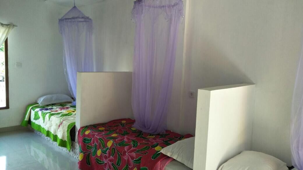Une chambre à coucher avec deux lits, chacun doté d’un baldaquin.