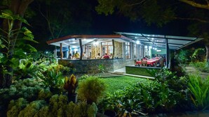 A modern house with a glass extension, surrounded by lush greenery. - Jays Holiday resort (Habarana)