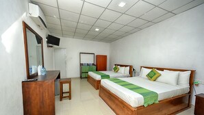 A hotel room with two wooden beds, a desk, a mirror, and a television. - Jays Holiday resort (Habarana)