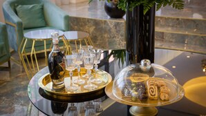 A table with a bottle of champagne, glasses, and a dessert display. - Hotel Corner (Split)
