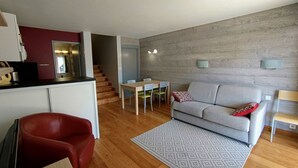 Ein moderner Wohnraum mit Küche, Essbereich und Sitzgelegenheit.