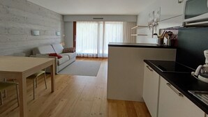 Eine moderne Küche mit Essbereich, Holzboden und grauer Wand.