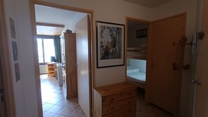 Una stanza con un settimino in legno, un quadro appeso al muro e un letto a castello in un angolo.