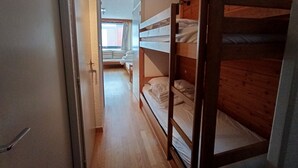 A narrow hallway with wooden bunk beds on one side and a window at the end. - Ski-in studio with private parking and pets allowed (Montgenèvre)