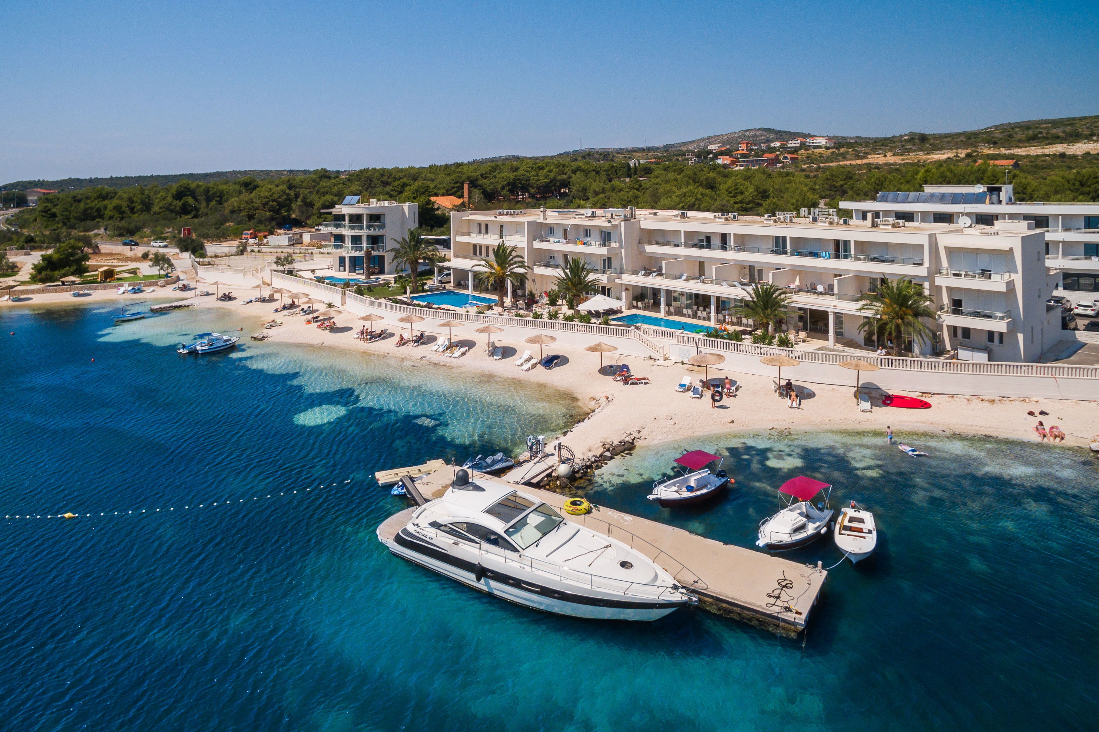 Un hôtel situé sur la côte, doté d’une piscine, d’une plage et de bateaux.
