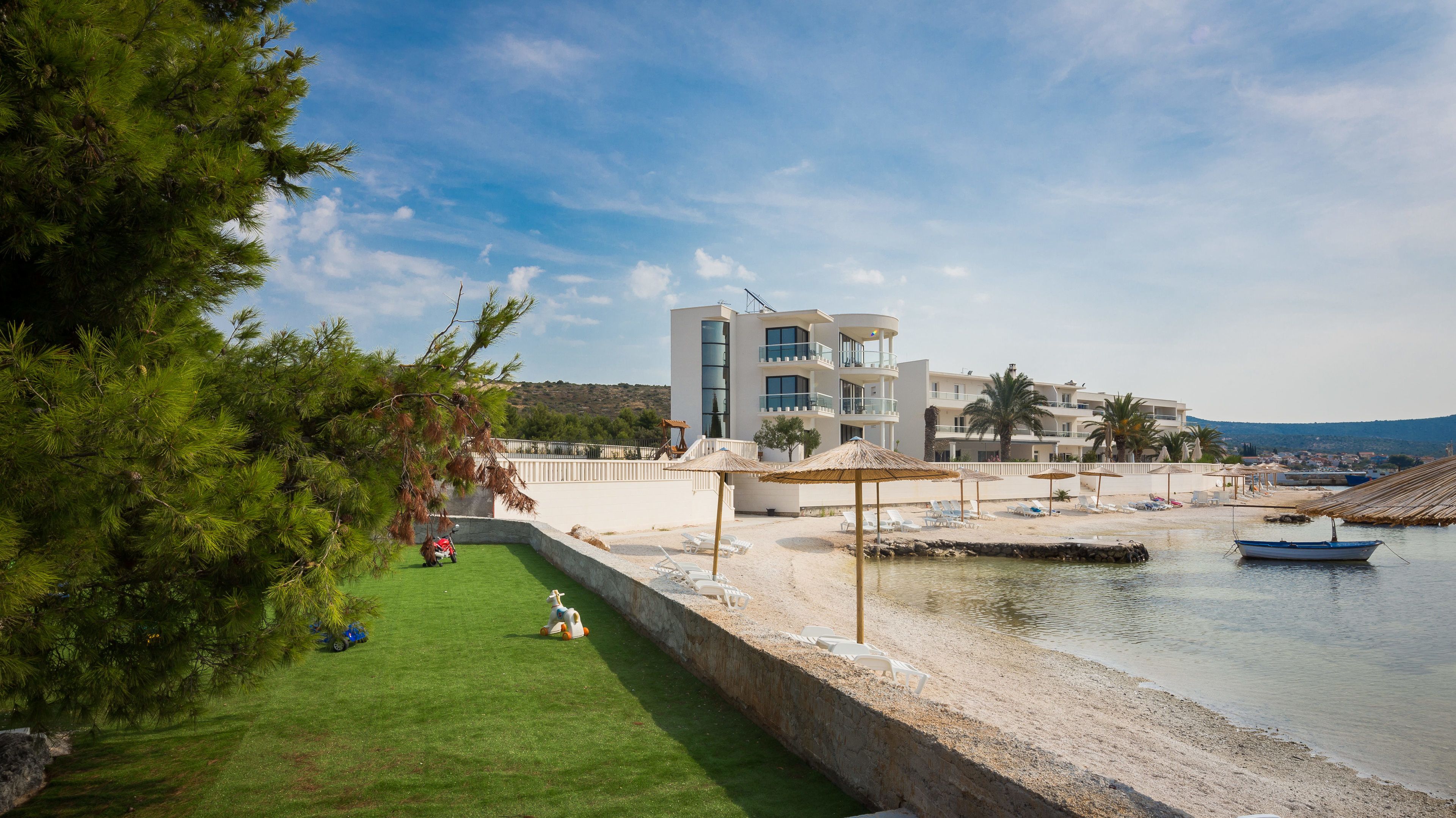 Un hôtel moderne doté d’une piscine, de chaises de plage et de parasols.