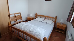 A neatly made bed with white bedding, wooden headboard, two bedside tables with lamps, and a small picture on the wall. - Apartment centrally located near slopes, pets allowed, parking included (Montgenèvre)