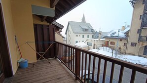 A wooden balcony with a metal railing overlooking a snowy street. - Apartment centrally located near slopes, pets allowed, parking included (Montgenèvre)