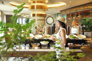 A buffet area with various food dishes, a clock on the wall, and a decorative ceiling.