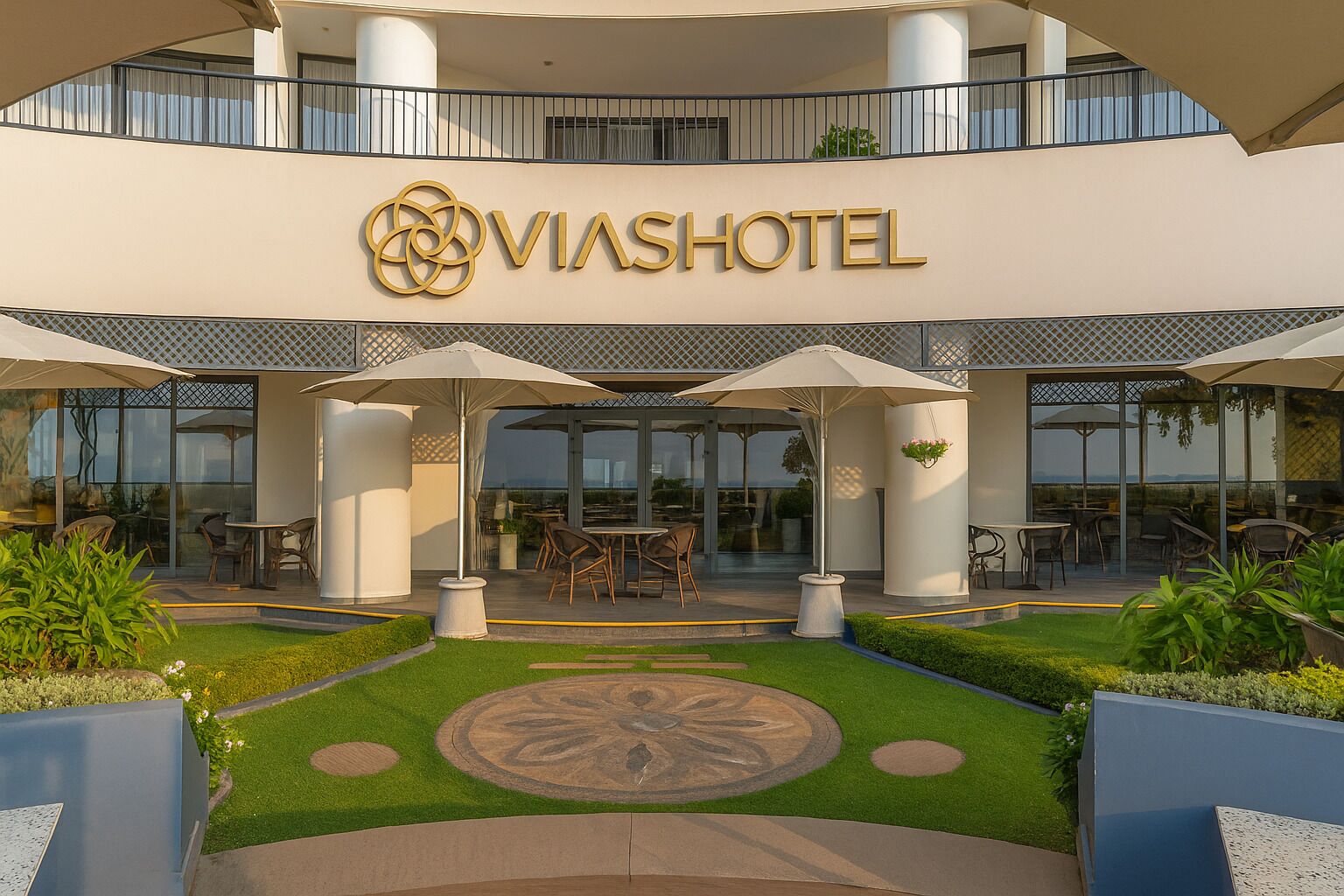 A hotel entrance with a modern design, outdoor seating, and a well-maintained garden.