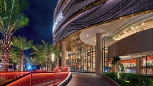 A modern hotel with a curved facade, large glass windows, and a well-lit entrance area. - Vias Hotel Vung Tau (Ho Chi Minh City)