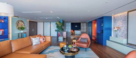 A modern living room with a sofa, armchairs, a coffee table, and a dining area with a buffet.