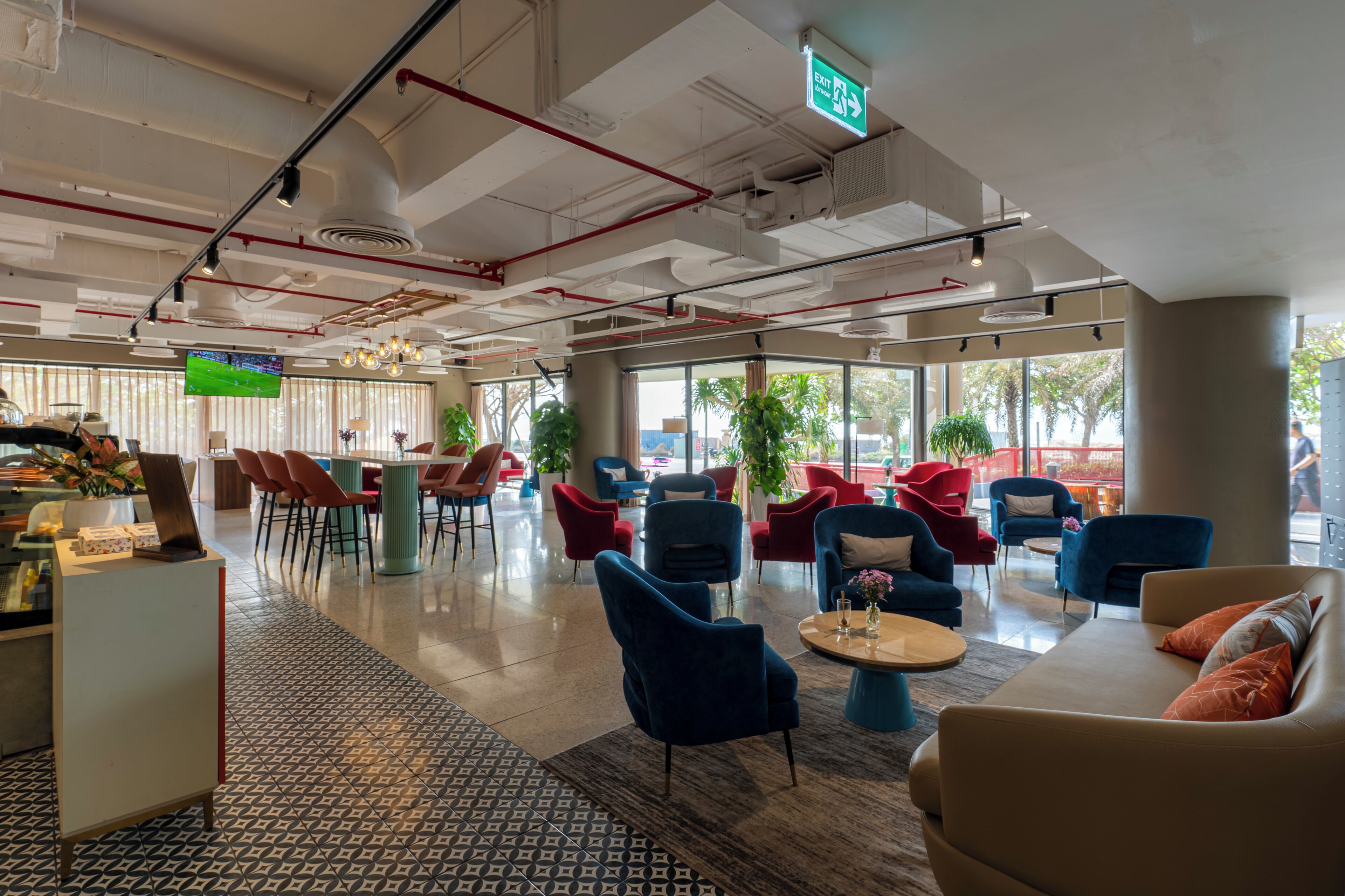 A spacious lobby with modern furniture, a reception desk, and large windows offering views of the outdoors.