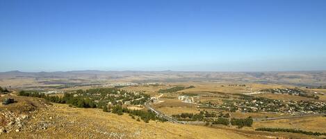 A panoramic view of a hilly landscape with a small town nestled among the hills.