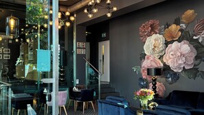 A modern interior with a wooden table, apples, brochures, and a floral mural. - Amber Suite Szczecin Adults Only (Szczecin)