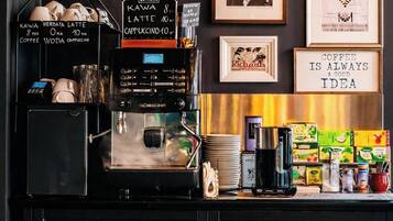 Una estación de café con un menú en pizarra, máquinas de café y diferentes productos de café.