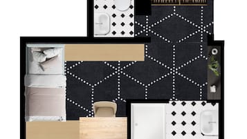 Un baño moderno con piso de diseño blanco y negro, un lavamanos blanco, un inodoro y una zona de ducha.