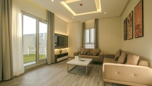 Una sala de estar moderna con un sofá, una mesa de centro y un televisor.