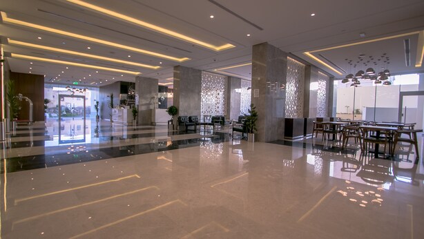 Un moderno vestíbulo de hotel con piso pulido, mobiliario contemporáneo e iluminación decorativa.