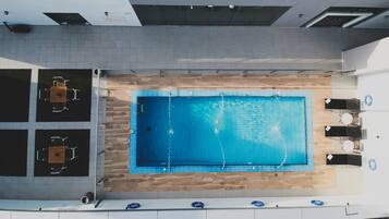 Una piscina al aire libre, tumbonas