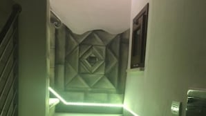 Een trap met geometrische wandpatronen en groene verlichting.