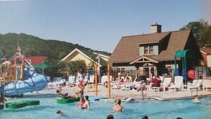 A swimming pool area with water slides and lounge chairs.