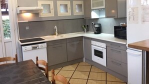 Una cocina compacta con horno integrado, microondas y cafetera.