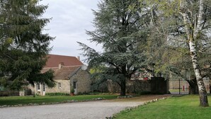 Una casa de piedra con camino de grava y patio cercado.