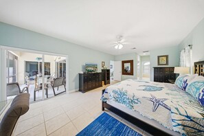Une chambre à coucher comprenant un lit, un bureau, une chaise, une armoire et un ventilateur de plafond.