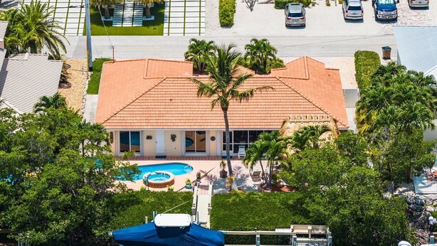 A hotel with a swimming pool, a covered boat dock, and a parking lot. - P13 - Loggerhead House 3 Bedroom Home with Private Pool (Key Colony Beach)