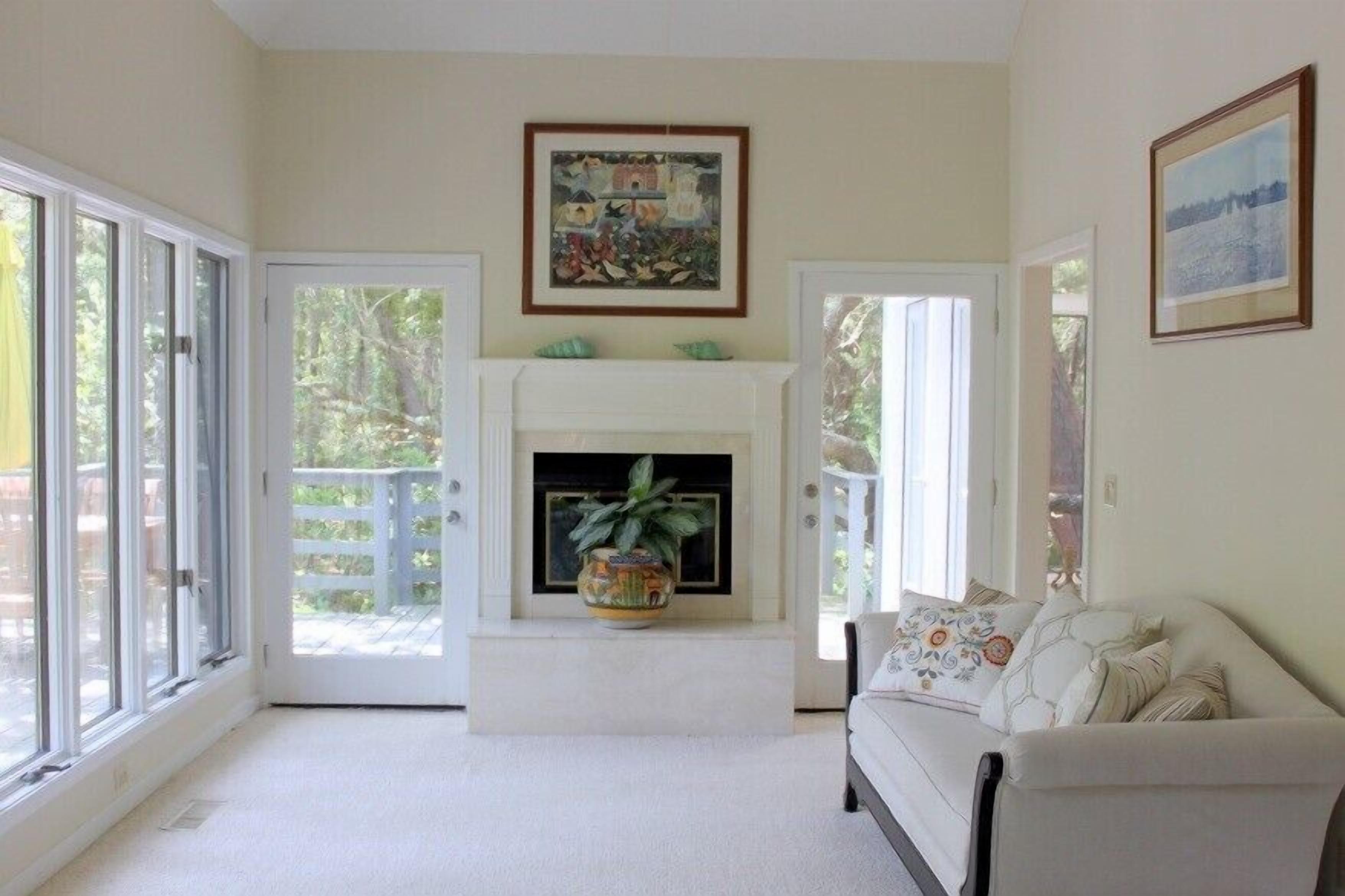 A living room with a fireplace, a sofa, and a large window.