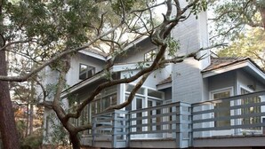 A two-story house with a balcony and a tree in the foreground. - Charming, family friendly and updated kitchen (Kiawah Island)